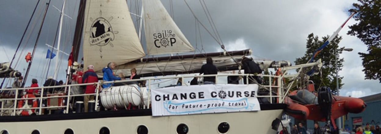 The boat shortly before setting sail with banner proclaiming 'change course'