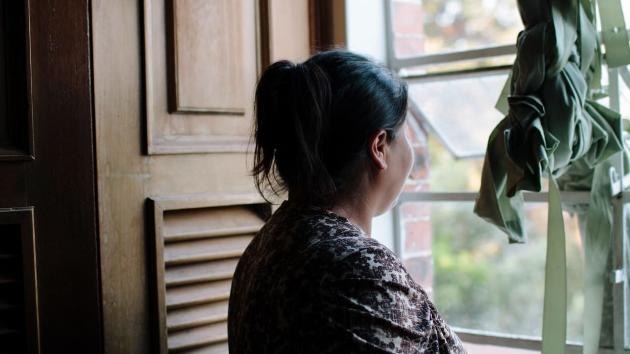 Photo of woman looking out of the window