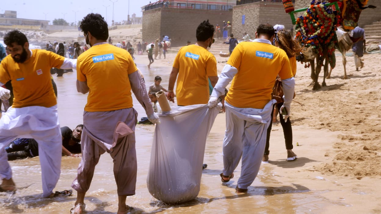 Four people in Tearfund shirts collecting litter