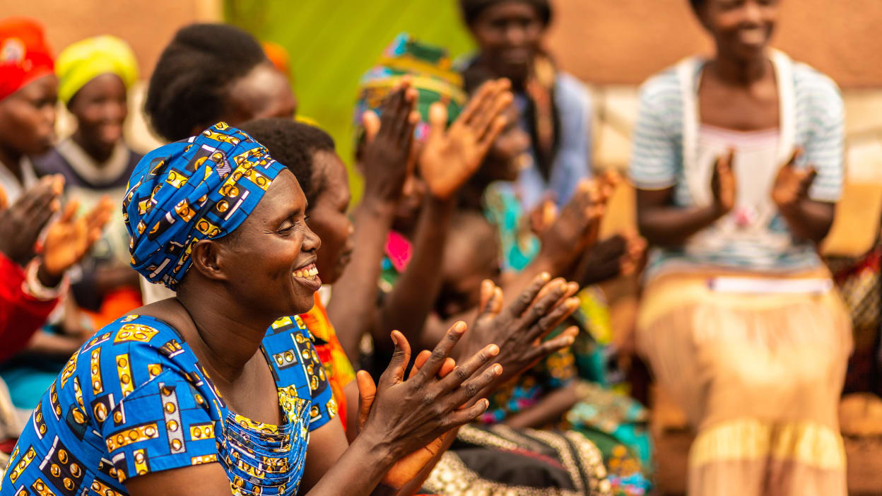 A group of smiling women sitting together and clapping