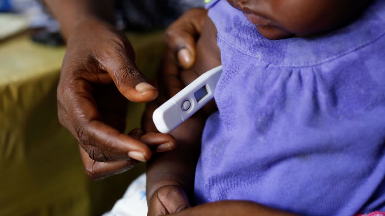 A young child having their temperature checked.