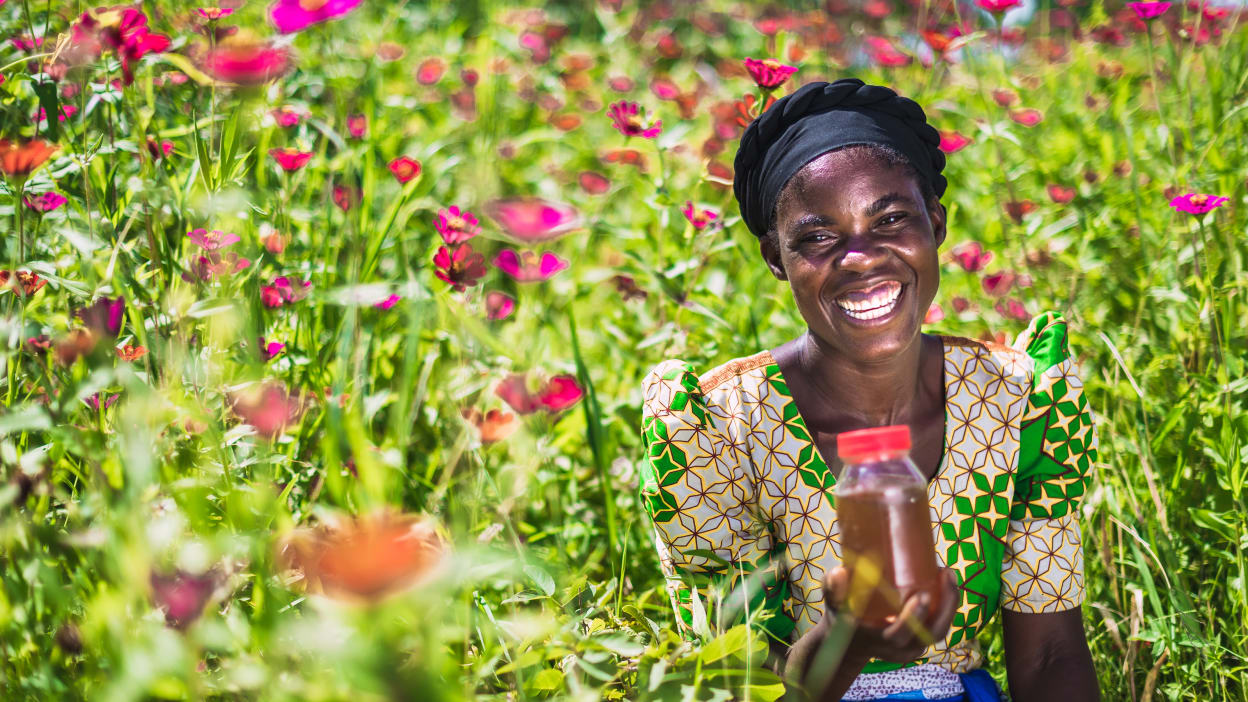 A woman holding a jar of honey.
