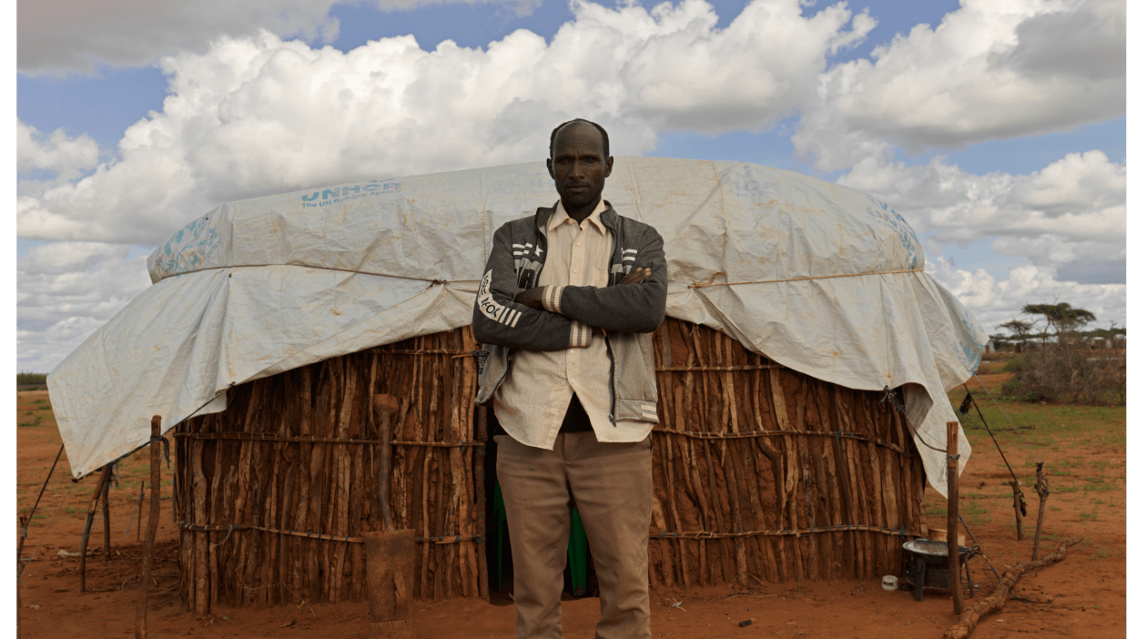 Godana in Ethiopia stands in front of the shelter he made for his family from sticks and mud and a tarpaulin provided by the UN. The family was forced to leave their home and come to a camp for internally displaced people to find food assistance after five years of drought in the region killed all their livestock.