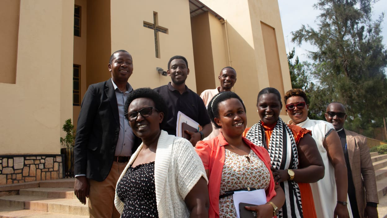 A group of people pose for a photo in front of a church building.