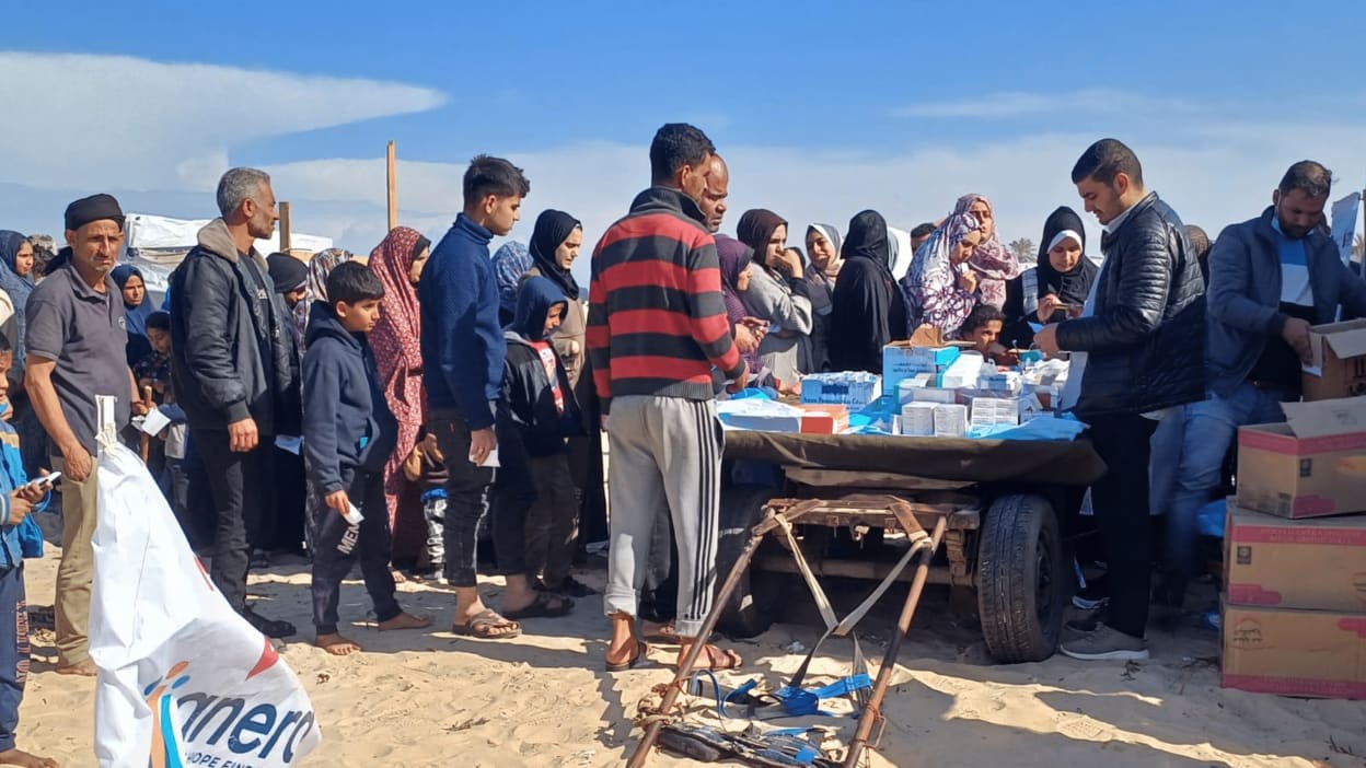 Men, women and children in Gaza queue to receive medical treatment at a mobile health clinic.