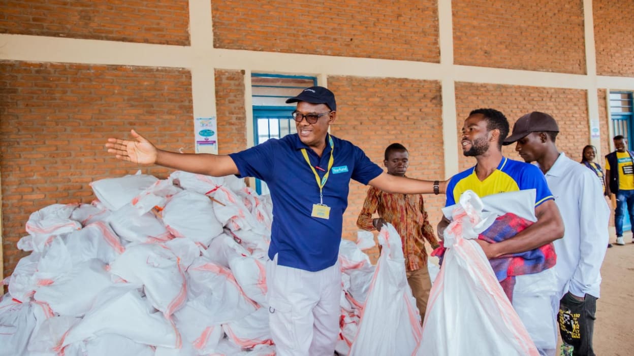 Country Director for Burundi, Desire Majambere, helps distribute emergency relief packs, including food, blankets and cooking utensils, to Congolese refugees in Burundi. 