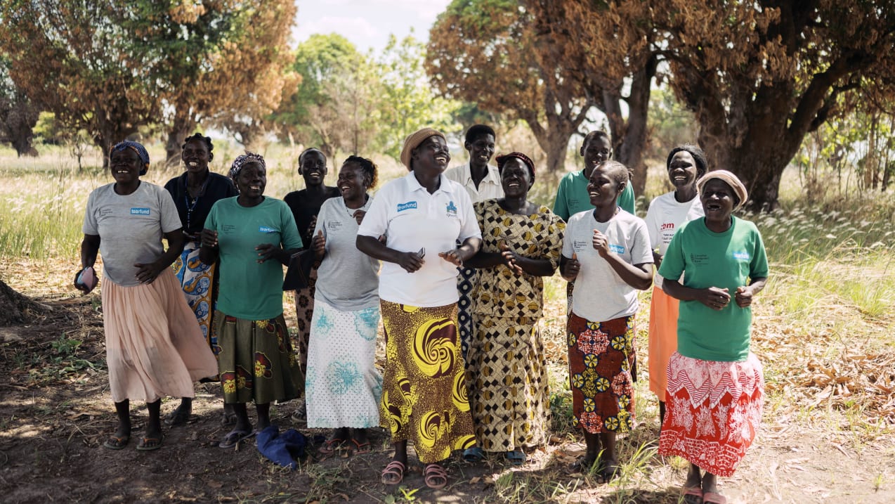 Group of women singing and dancing in a field.