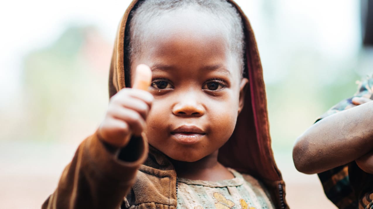 Smilling child giving a thumbs up