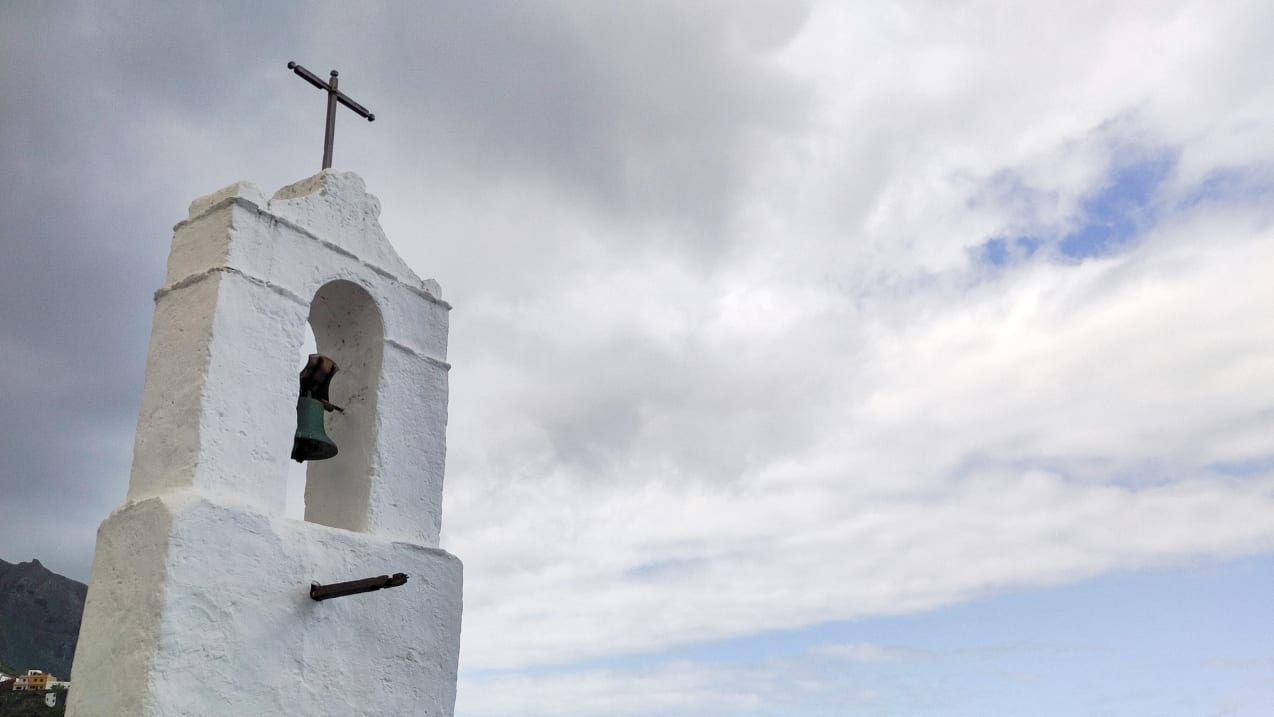 White stone church steeple with the sky in the background