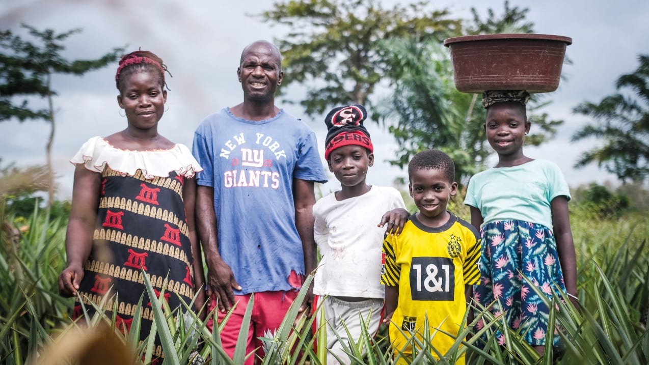 Two adults and three children standing together in a field