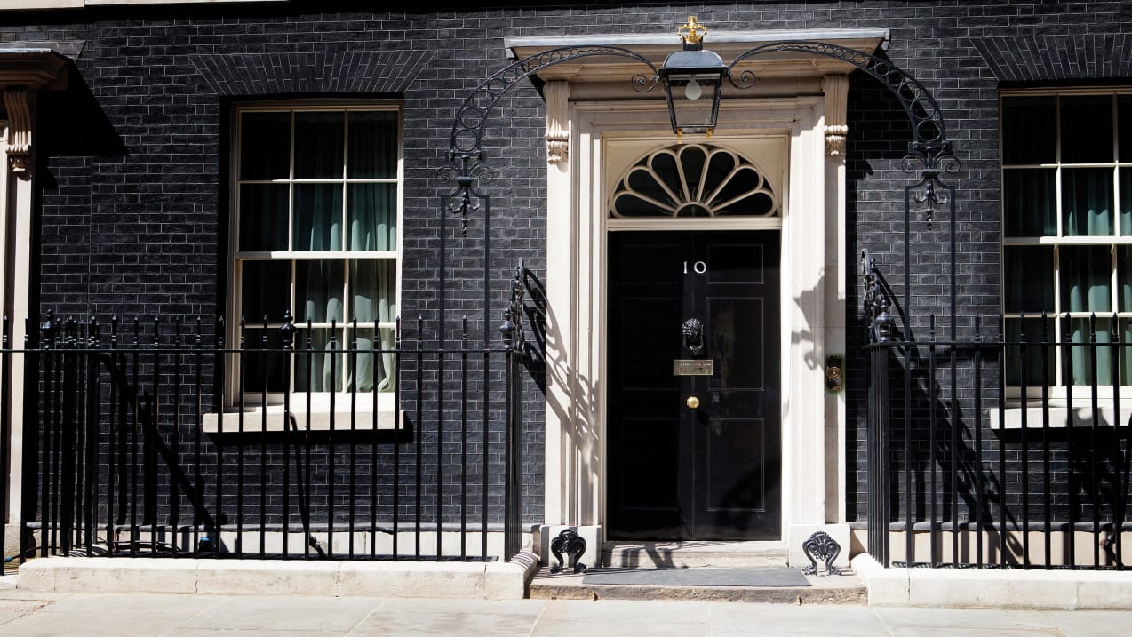 A photo of the door of 10 Downing Street on a sunny day.