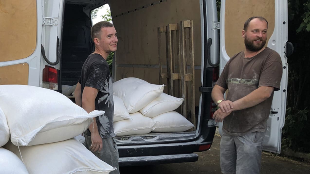 Two man loading supplies into the back of a van