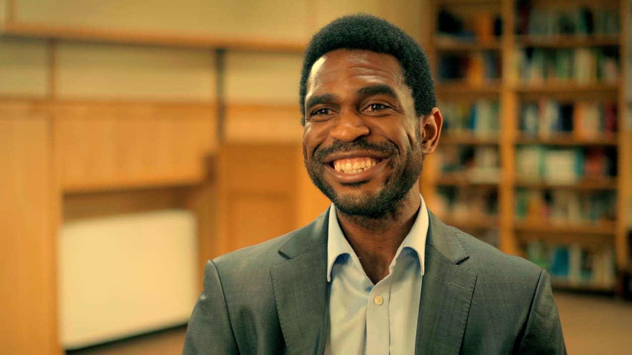 A man in a suit smiling