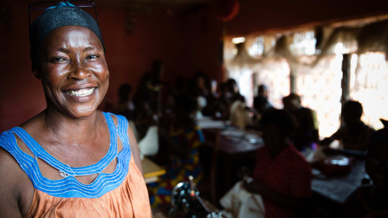 A woman smiling at the camera with people in the background