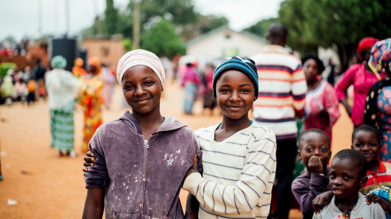 Two girls stand shoulder to shoulder at a refugee camp in Nigeria