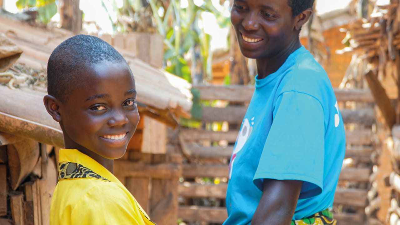 Une mère burundaise souriante regarde sa fille qui sourit à l'objectif