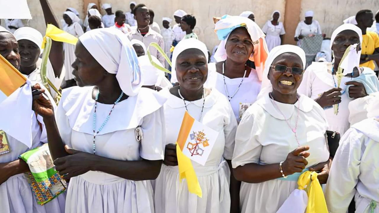 A large group of smiling African women all dressed in white.