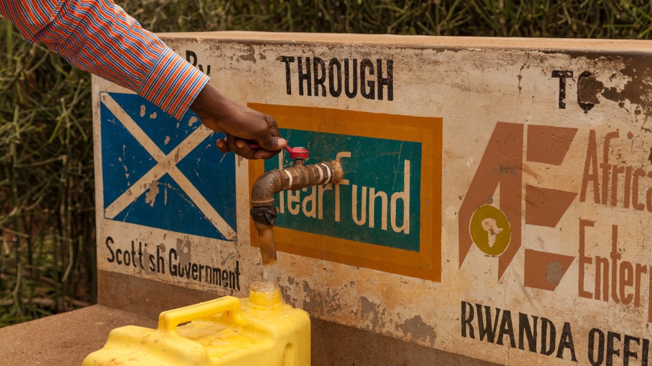 A member of the local community gathering water from a community water tap in the Gisagara district of Rwanda, where Tearfund are working with partner African Evangelistic Enterprise. Photo: Chris Hoskins/Tearfund