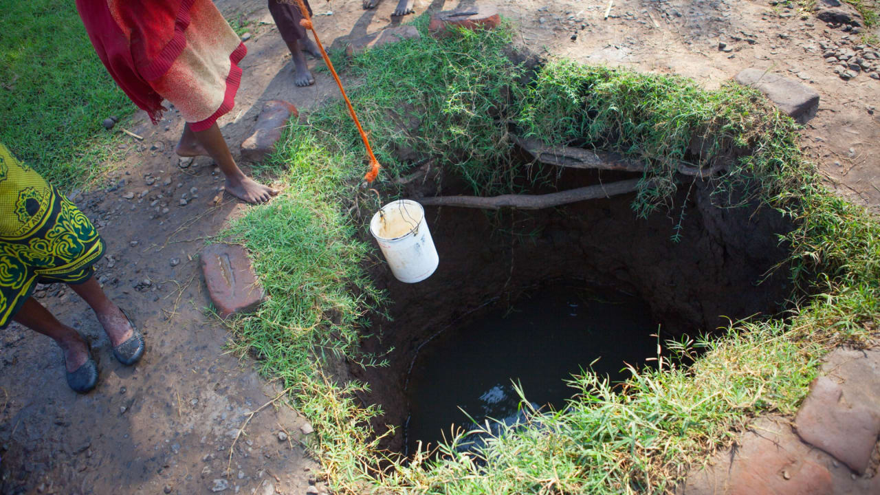 People collecting water from a dug well in rural Malawi. Photo: Clive Mear/Tearfund