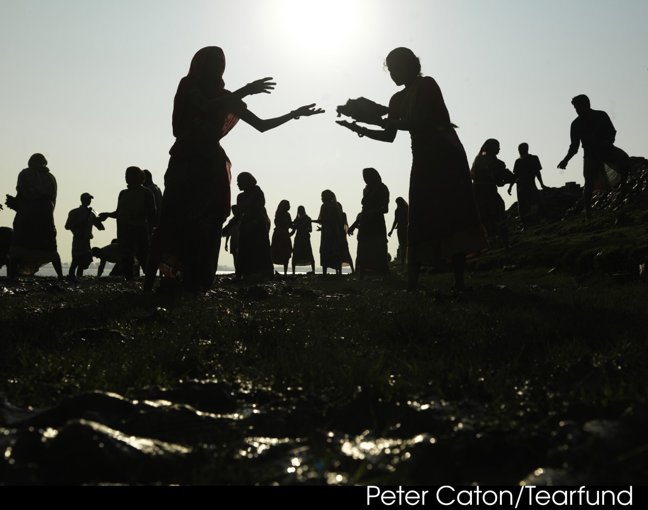 Villagers building higher and stronger dykes to create a barrier against the rising sea levels due to climate change. Photo: Peter Caton/Tearfund