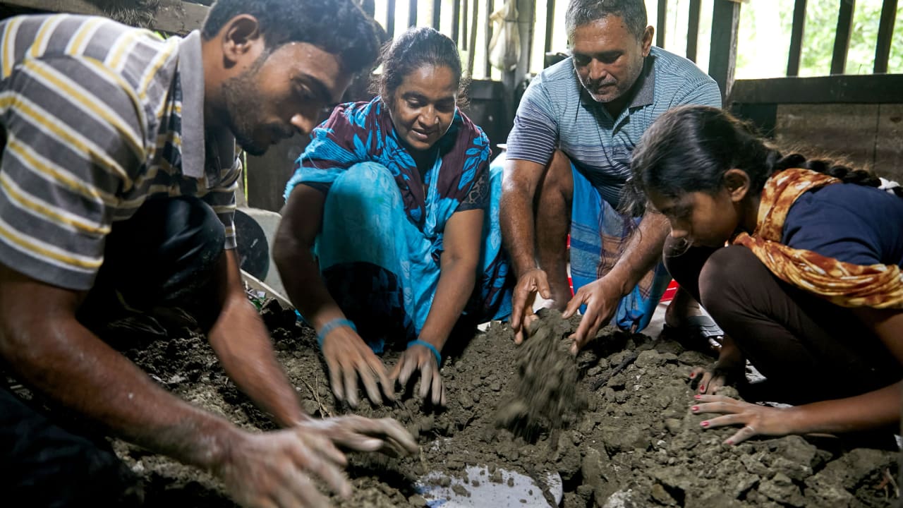 A family in Bangladesh preserve dry foods and other essentials (biscuits, rice, matches etc) prior to going to a cyclone shelter