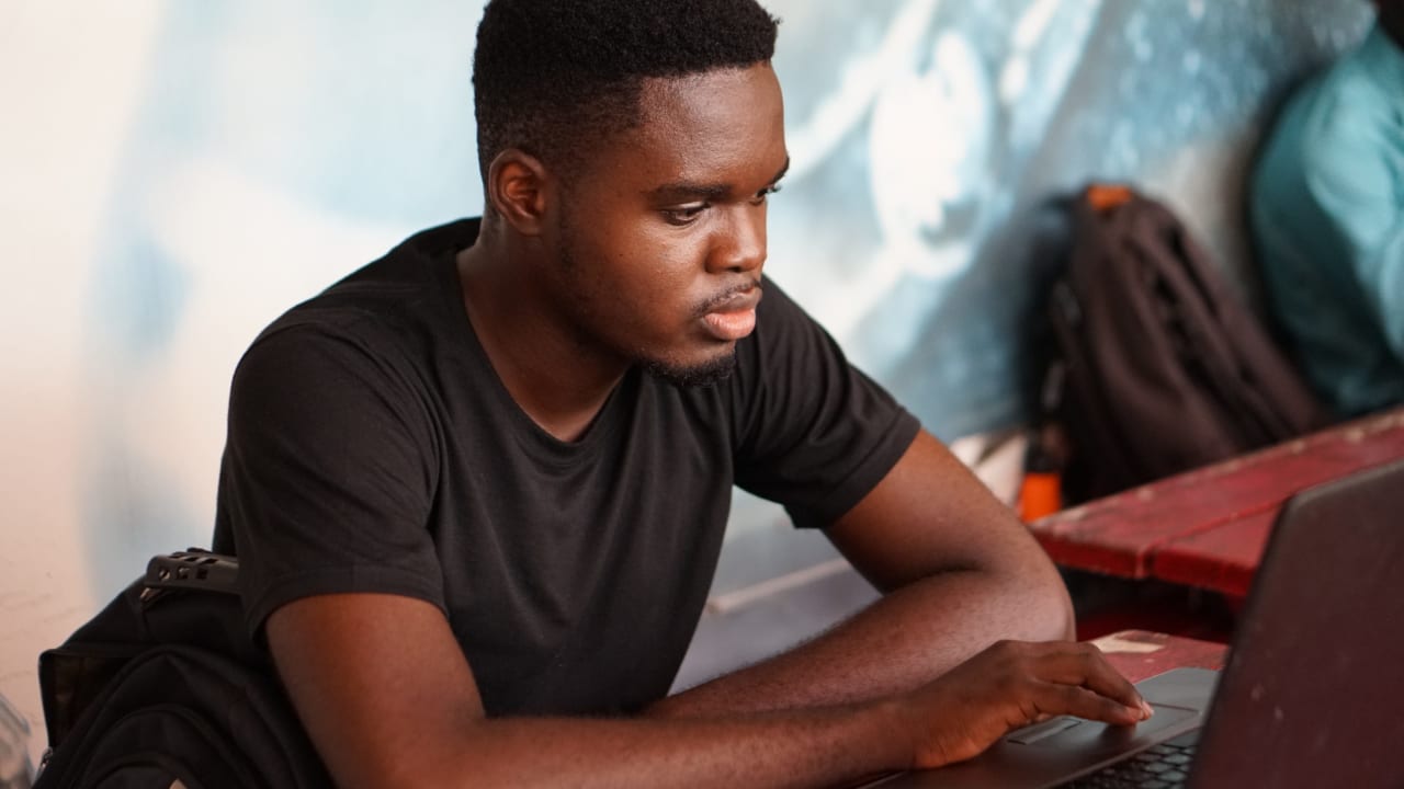 A man in Ghana does research on his laptop