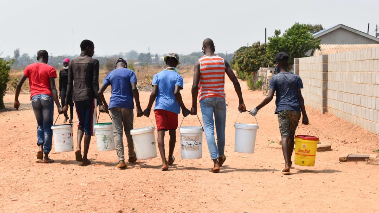 Young boys work together to carry water home