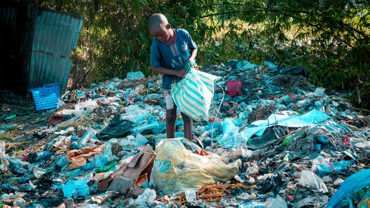 Photo of boy picking up plastic waste