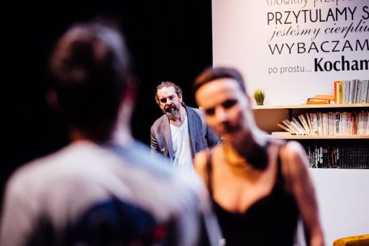 Na pierwszym planie zamazana sylwetka Łukasza (Adam Turczyk) i twarz Anny (Sylwia Góra). W tle wyostrzona, zmartwiona twarz Szczepana (Marek Tynda).