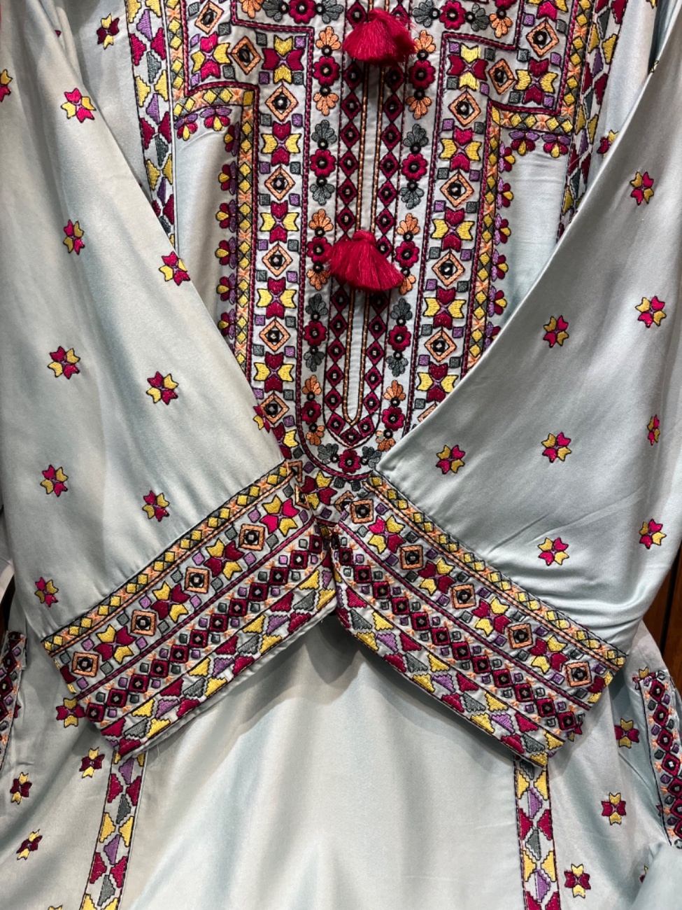 Elegant light green suit featuring intricate multicolor ethnic embroidery on the neckline, daman and sleeves with stylish tassel detailing, paired with a matching bottom and a beautifully printed dupatta-1