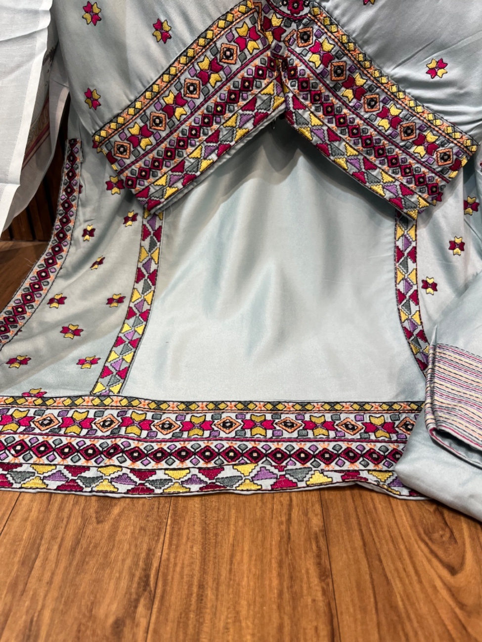Elegant light green suit featuring intricate multicolor ethnic embroidery on the neckline, daman and sleeves with stylish tassel detailing, paired with a matching bottom and a beautifully printed dupatta-2