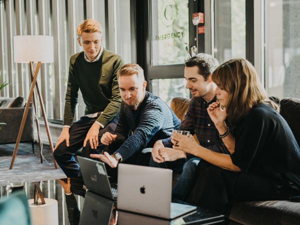 A group of people looking at a laptop.