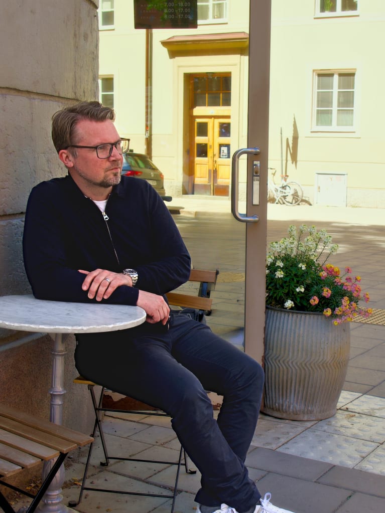 A person sitting on a wooden bench – Gustaf Lindqvist