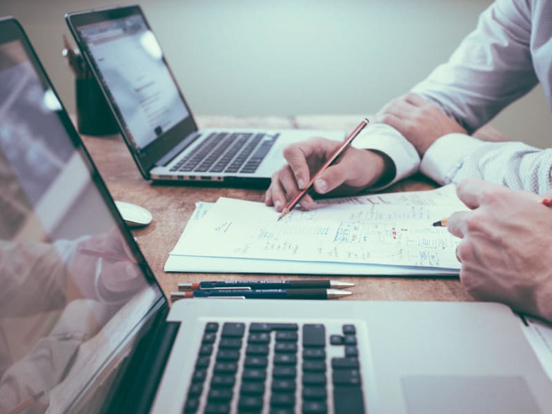 En person som håller i en penna och skriver på ett papper.