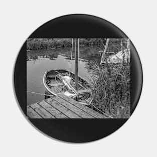 Small wooden boat moored to a quay heading on the Norfolk Broads Pin