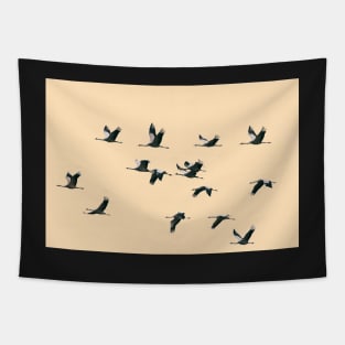Fifteen Common Cranes Flying on Peach Background Tapestry