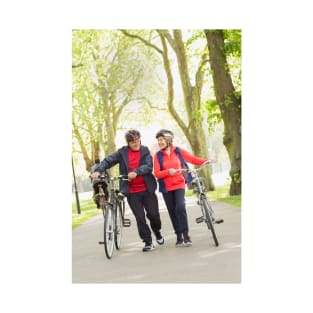 Active senior couple walking bicycles in park (F023/0128) T-Shirt