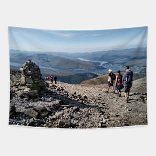 Hikers pass a navigation cairn as they descend back down Ben Nevis Tapestry