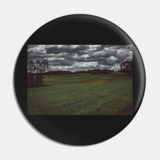 Dark moody sky over meadow and forest Pin