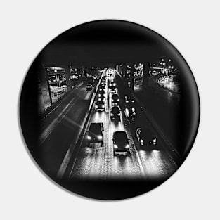 A black photo of cars on a highway at night. Pin