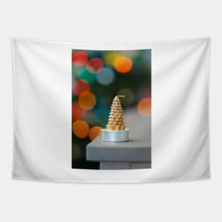 Christmas tree shaped candle on wooden cupboard against christmas lights Tapestry