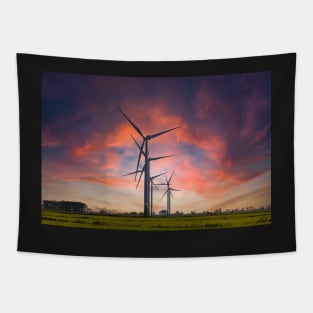 Windmill farm on green meadow under moody red sky Tapestry