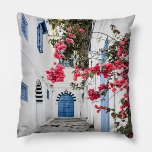 Alley with blue door and pink blossom in Tunisia Pillow