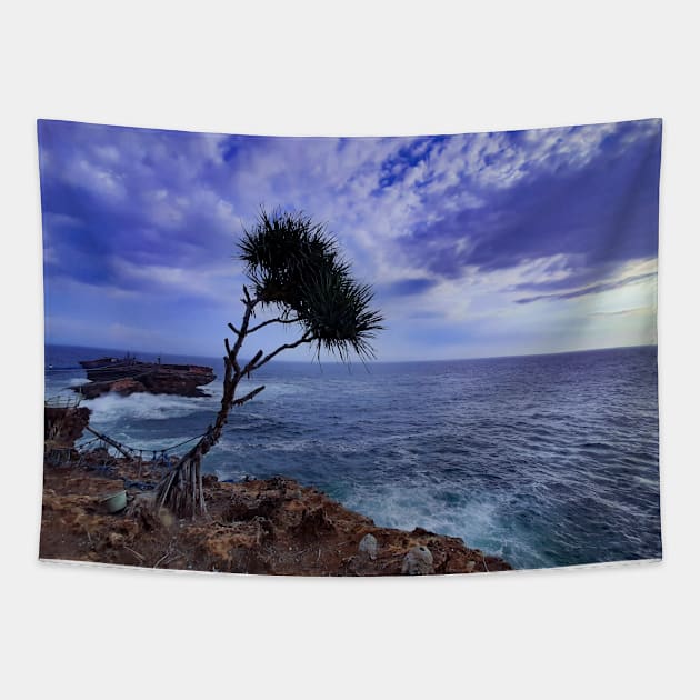 A palm tree on rock plateau with a rock island in the sea Tapestry by kall3bu