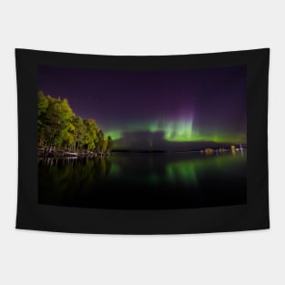 Northern lights glowing over lake in Finland Tapestry