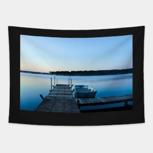 Wooden dock and a boat on blue clear water Tapestry