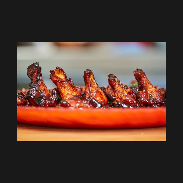 Caramelized chicken wings in closeup by naturalis