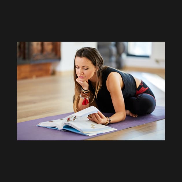 Young woman reading a yoga book by naturalis