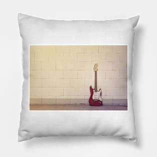 Red electric guitar against white brick wall Pillow