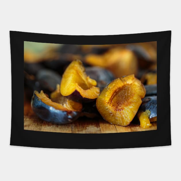 Plums sliced on a wooden board Tapestry by naturalis